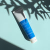 Balancing Daily Moisturizer tube on blue background with shadow
