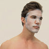 A man has a translucent Intense Recovery Treatment Mask on his face.